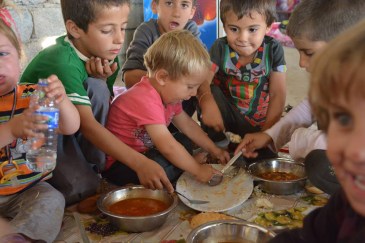 In Khanke village, Iraq Kurdistan Region, children from the Yazidi minority eat a meal of rice and tomato stew for lunch. Photo: UNHCR/N. Colt