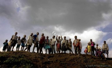 © UNICEF/NYHQ2008-1227/Holt | Children stand on a hilltop overlooking a UNICEF-assisted child-friendly space in a Kibati camp for the displaced near Goma, Democratic Republic of the Congo.