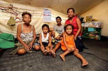 © UNHCR/P.Behan | Three generations of the Aguilar family pose for a photo in their UNHCR tent.