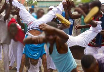 © UNICEF DRC/2015/Muntzer The capoeira students practice their moves, while Ninja gets support doing a handstand. 