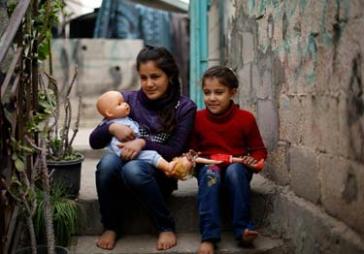 © UNICEF/NYHQ2015-0256/El Baba Samar and Rosol sit on the steps outside their grandfather’s home in Beit Lahia, Gaza.