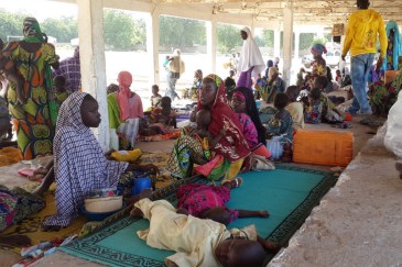 A group of Nigerian refugees rest in the Cameroon town of Mora after fleeing armed Boko Haram attacks. Photo: UNHCR/D. Mbaoirem