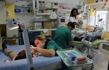        Print     Leaflet     Feedback     Share » The social crisis in Greece: Part Two “If you visit a hospital right now you will see that they are in shambles” By our reporters 11 March 2015 This is the second article of a two-part series on the social crisis in Greece. Part one was posted March 10. Today 3 million Greeks, around a quarter of the population, have no health insurance and no right to receive state-funded health care. The European Union, European Central Bank and International Monetary Fund’s Greek austerity programme insists that spending on public health cannot rise above 6 percent of GDP. According to the Organisation for Economic Cooperation and Development (OECD) figures, health spending per head in Greece dropped by 25 percent between 2009 and 2012, and has not improved since. Imposing these unprecedented cuts has destroyed an advanced public health care system built up over decades. The human cost has been staggering. Two health care trade unions issued figures in September 2014 showing that 850 medical clinics have been abolished, 10,000 beds shut down and 30,000 front-line positions removed. Eleven hospitals have closed since the beginning of the crisis. Six thousand doctors at public clinics have been laid off. Funding for mental health care has been slashed by 55 percent. Public spending on pharmaceuticals has more than halved, leading to 200 medicines being destocked by pharmacies. The budget cuts have led to new fees for prescriptions and charges for outpatient visits to hospital being raised from €3 to €5. Evgenia Thanou is the general manager of Medicin du Monde (Doctors of the World). It provides free health care to those who can’t afford it and has five poly-clinics in Greece. The organisation provides other vital services, including helping 1,800 families with food supplies. Evgenia Thanou Thanou told the World Socialist Web Site, “In an interview three years ago Doctors of the World predicted that Greece was on the verge of a humanitarian crisis. … At the time we were told that we were being over the top—not just by the government, but also by other NGOs, which didn’t see this coming. “Unfortunately we have been proved correct. If you visit a hospital right now you will see that they are in shambles. You will see patients in wards, but no staff. You will see relatives at the bedside of patients carrying out nursing duties.” Thanou continued, “In July last year the Greek government issued health cards to people with no medical coverage. According to official statistics there are around 3 million people in Greece without such coverage, but these cards were given out to only 500,000. These cards do not grant full access to the health care system every time a person gets sick, but only cover a maximum of one sickness event per year. In effect these people are still without cover. For instance, if I get the flu now and I use my card, then if I get sick again in spring I won’t have access to the health care system.” In 2012, a mother was told she would not be able to take her newborn baby home: “The woman was uninsured and went to a public hospital to give birth, but because she could not pay for the delivery the hospital authorities would not give her the baby. Our organization intervened in this case and publicized it. As a result, babies are not taken away from mothers anymore. However, the debt is not written off, but is transferred onto the tax code of either the mother or the father.” This has created new problems since if a person owes more than €5,000 in tax then an immediate arrest warrant is issued and he or she is taken into custody until that debt is paid off: “For example, the situation of a woman with no health coverage giving birth in a public hospital would typically indicate that her husband already owed money in tax and for this reason had not kept up with payments into his health insurance fund and had other expenses to cover. “Hence, even though the mother could take the baby home, there would be a danger that the husband would go to jail. In one case our organization paid the €1,500 cost of delivery so that the woman’s husband would not go to jail.” Dental workers treating children at the Doctors of the World headquarters in Athens