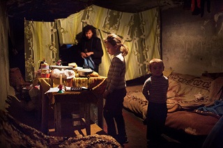 © UNICEF/NYHQ2014-3500/Volpi | Natalia and her little brother, Ivan, stand in the bomb shelter where they and their mother have sought refuge as a result of the ongoing conflict, in the city of Donetsk in Ukraine.