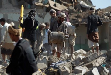 Yemeni civilians search the rubble of buildings destroyed during Saudi airstrikes near Sanaa Airport | Source: Middle East Eye