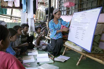 On the weather-beaten porch of a small terrace house in the town of Kelang, 13-year-old Rohingya refugee Jamilah gives a lesson on Islamic studies. Her community can neither afford to hire a teacher nor send their children to public schools in Malaysia. | UNHCR
