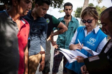 UNHCR staffer helps refugees and migrants to register at the local police station on Kos Island in Greece. Photo: UNHCR/S. Baltagiannis