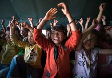 © UNICEF Nepal/2015/Sokol | Jamuna sings along with other children at the child-friendly space set up in the camp.