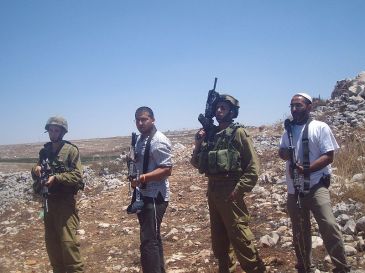 ***Image: IDF soldiers and Israeli settlers |Author: ISM Palestine | Wikimedia Commons