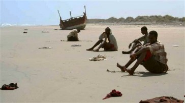 **Photo: J.Björgvinsson/UNHCR | Exhausted survivors of the Gulf of Aden crossing wait for help on a beach in Yemen (file photo)