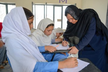 Afghan refugee teacher Aqeela Asifi (right), named as the winner of the United Nations annual Nansen Award. During classes, she pays attention to individual students and monitors their progress. Photo: UNHCR/Sebastian Rich