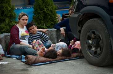 © UNHCR/I.Szabó | Influx of refugees from FYR Macedonia to Serbia includes exhausted mothers with children resting in any kind of shade they can spot.