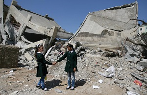 © UNICEF/NYHQ2014-1771/El Baba | Classmates hold hands while standing beside rubble from a destroyed part of the Shuje’iyah Girls’ School in eastern Gaza City.