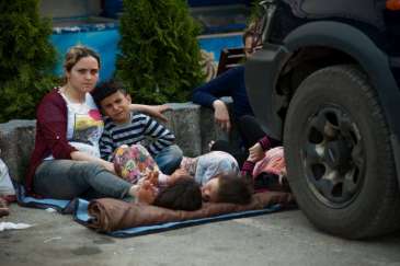 © UNHCR/I.Szabó | Influx of refugees from FYR Macedonia to Serbia includes exhausted mothers with children resting in any kind of shade they can spot.