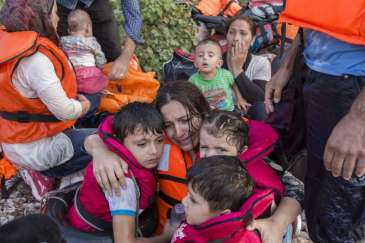 ******© UNHCR/I.Prickett | A Syrian woman cries in relief as she embraces her three young children after a very rough crossing of the Aegean from Turkey to the Greek island of Lesbos.