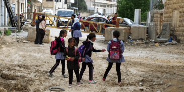 Children heading home from school pass the yellow steel gate at Qafisheh checkpoint in Hebron's Tel Rumeida neighborhood on 2 May 2019. (Photo_ Ivan Karakashian_NRC)